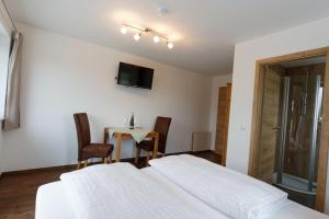 a bedroom with a bed and a table with chairs at Pension Christina in Vaihingen an der Enz