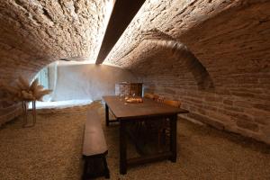 a dining room with a table and a brick wall at Maison de vacances avec cave voûtée entre Lyon et Beaune in Givry