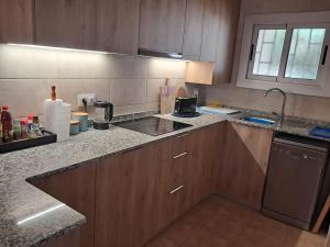 a kitchen with wooden cabinets and a counter top at Cal Jamila in Cubelles