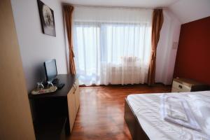 a bedroom with a bed and a desk with a computer at Vila Residence in Moieciu de Sus +3 photos
