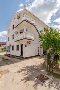 a white building with a balcony on the side at Apartman studio in Privlaka