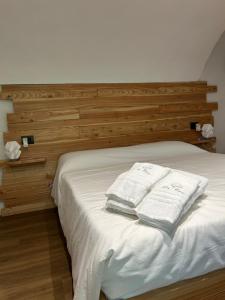 a bedroom with a bed with two towels on it at Da Noi Panoramic Guest Stay Camera Rifugio in Cuorgnè
