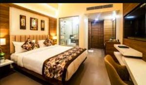 a bedroom with a large bed and a desk at Hotel shanti palace in Agra