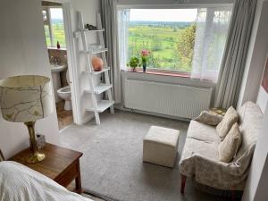 a living room with a couch and a window at Magic of Avalon in Glastonbury