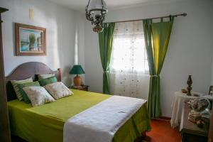 a bedroom with a green bed with a window at Casa dos Alpendres in Avis +42 photos