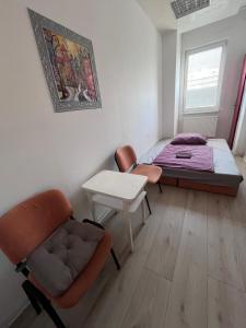 a bedroom with a bed and a chair and a table at Single Room Old Town in Košice
