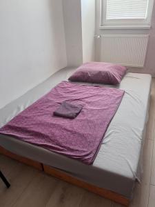 a bed with a purple blanket on top of it at Single Room Old Town in Košice