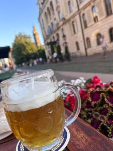 a glass of beer sitting on a table in front of a building at Single Room Old Town in Košice