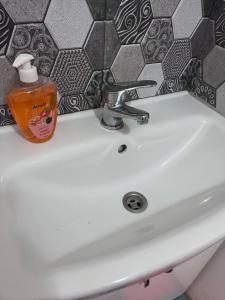 a white sink with a bottle of soap on it at Single Room Old Town in Košice