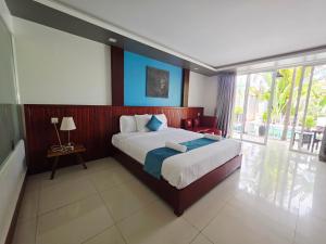 a bedroom with a large bed and a large window at Angkor Sweet Night Hotel in Siem Reap