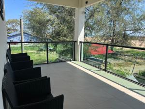 a screened porch with chairs and a view of a house at Luminara Villa Kuala Besut in Kampung Kuala Besut