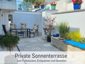 a patio with a table and chairs and plants at Die Perle am Teich ist Ihre exklusive Ferienwohnung mit Klimaanlage und großer Terrasse im Harz in Ballenstedt