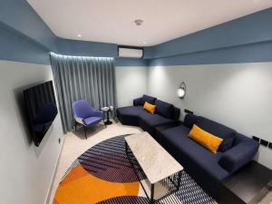 a living room with a blue couch and chairs at Ibis Styles Subic in Olongapo