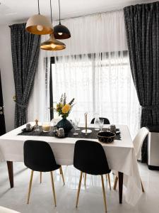 a dining room with a white table and chairs at Le Refuge du Lac Rose in Ouayembame +5 photos