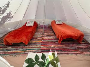 two red pillows are sitting in a tent at Pear Tree Bell tent in Charlton +10 photos