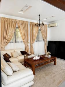 a living room with a white couch and a coffee table at Le Refuge du Lac Rose in Ouayembame