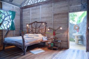 a bedroom with a bed in a wooden wall at Danta Corcovado Lodge in Rincón