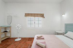 a white bedroom with a bed and a window at Casa Veronica in Arona