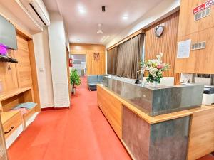 an office lobby with a reception counter with flowers at Hotel Royal Relax in Gandhinagar