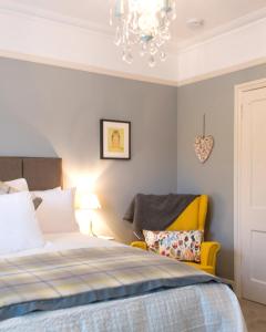 1 dormitorio con cama y lámpara de araña en April House Weybridge - Boutique Guesthouse, en Weybridge
