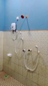 a shower in a bathroom with hose attachments on a wall at Zeenath Villa - Arugambay in Arugam Bay