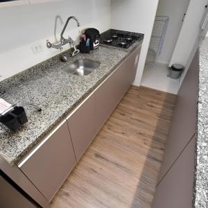 a kitchen with a sink and a wooden floor at Apart 1803 - Centro Curitiba in Curitiba +19 photos