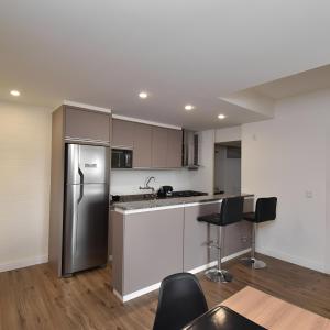 a kitchen with a refrigerator and a table and chairs at Apart 1803 - Centro Curitiba in Curitiba