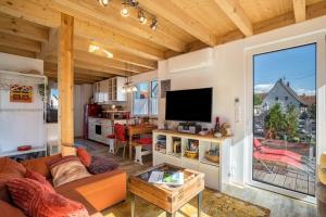 a living room with a couch and a tv at Haus Himmelblick mit privater Sauna in Sasbach am Kaiserstuhl