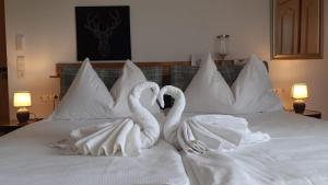 two swans dressed in white are sitting on a bed at Appartement Sunset, 28qm in Schluchsee +5 photos