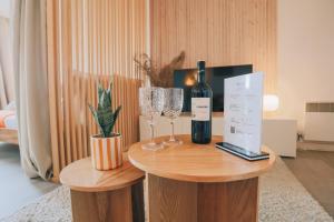 a bottle of wine and two glasses on a table at Vue mer, sur le port, près des tours in La Rochelle
