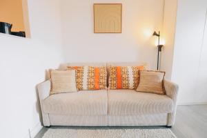 a couch with pillows on it in a living room at Vue mer, sur le port, près des tours in La Rochelle