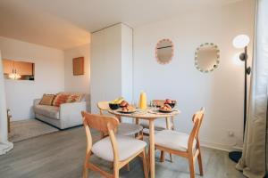 a kitchen and living room with a table and chairs at Vue mer, sur le port, près des tours in La Rochelle