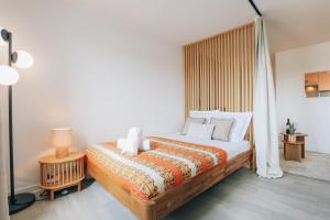 a bedroom with a bed with a wooden headboard at Vue mer, sur le port, près des tours in La Rochelle +12 photos