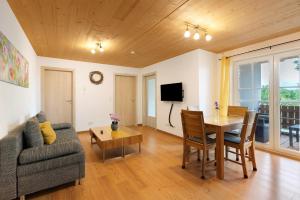 ein Wohnzimmer mit Sofa, Tisch und Fernseher in der Unterkunft Ferienhaus Heerlichkeit in Löffingen