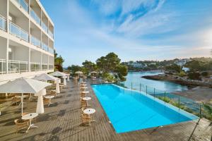 an image of a hotel pool with chairs and umbrellas at Grupotel Ibiza Beach Resort - Adults Only in Portinatx +40 photos