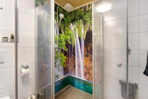 ein Badezimmer mit einem Wasserfall-Wandbild an der Wand in der Unterkunft Ferienhaus Heerlichkeit in Löffingen + 68 Fotos