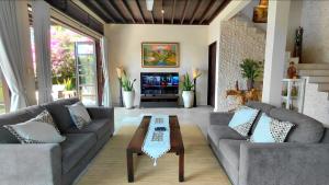 a living room with couches and a coffee table at Villa Terang Bulan - luxury private beachfront villa in Pengastulan