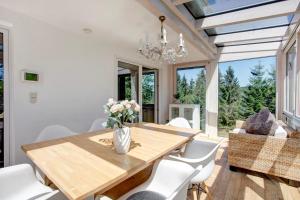 a dining room with a wooden table and white chairs at Haslehaus in Feldberg