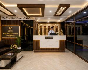 a man standing at a counter in a lobby at Hotel shanti palace in Agra