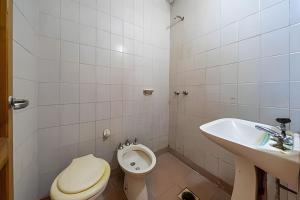 a bathroom with a toilet and a sink at "Alpha", downtown hotel room in Rosario