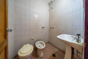 a bathroom with a toilet and a bidet and a sink at "Alpha", downtown hotel room in Rosario