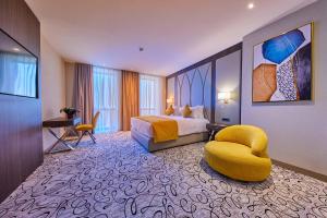 a hotel room with a bed and a chair at EDELWEISS HOTEL El Mouradia in El Mouradia
