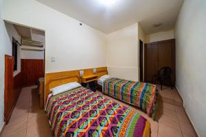 a bedroom with two beds and a table in it at "Alpha", downtown hotel room in Rosario