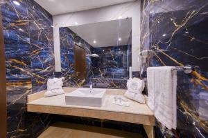 a bathroom with a sink and a mirror at EDELWEISS HOTEL El Mouradia in El Mouradia +16 photos