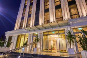 a facade of a building with palm trees in front at EDELWEISS HOTEL El Mouradia in El Mouradia