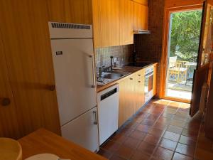 a kitchen with a white refrigerator and a sink at Beautiful chalet with exceptional views, very quiet in Gryon