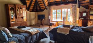 a bedroom with two beds and a table and a couch at Kudu Crescent Guesthouse in Harrismith