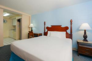 a bedroom with a large bed and a kitchen at Waikiki Heritage Hotel in Honolulu +65 photos