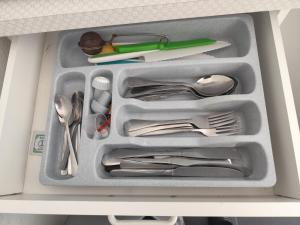 a drawer filled with silver utensils in a drawer at Appartement in Hannover