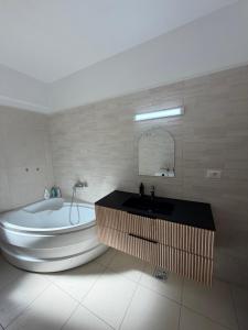 a bathroom with a tub and a sink and a bath tub at Apartament Valcea in Râmnicu Vâlcea +13 photos